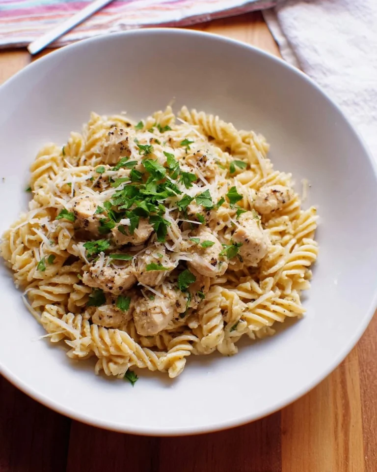 Crockpot Garlic Parmesan Chicken Pasta served in a bowl with herbs on top