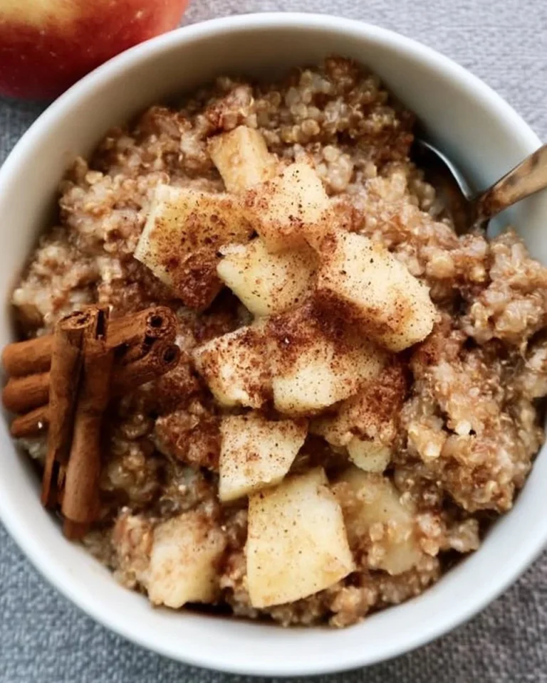 Healthy cinnamon quinoa apple breakfast served in a bowl with fresh apples and cinnamon