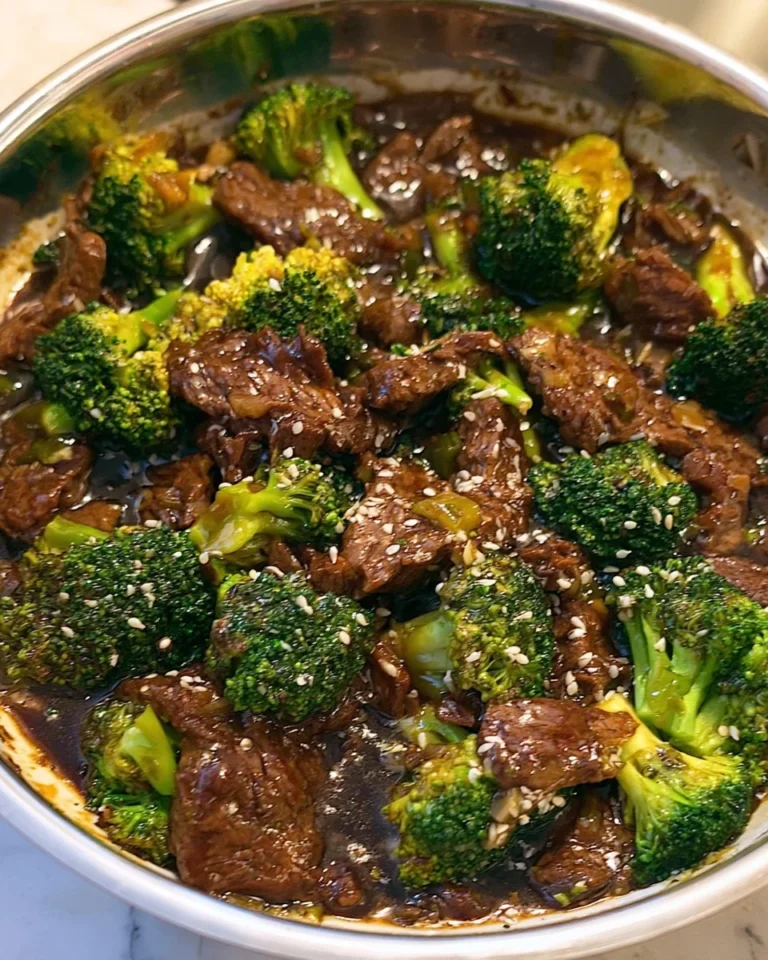 Homemade broccoli beef stir-fry on a plate with rice and vegetables